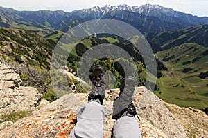 Hiker legs sit on mountain top