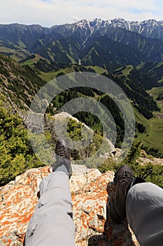 Hiker legs sit on mountain top