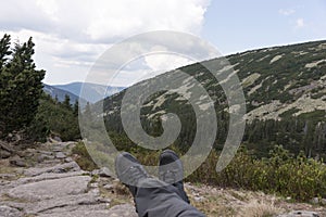 Hiker lies on the stones, with a view into the valley