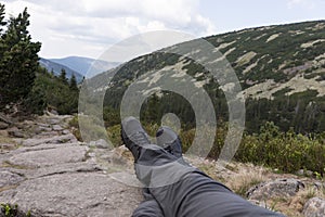 Hiker lies on the stones, with a view into the valley