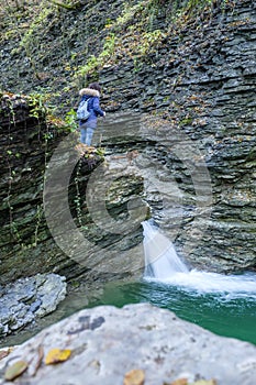 Hiker looking at the small waterfalls of the Rui stream, Mel, Belluno, Italy