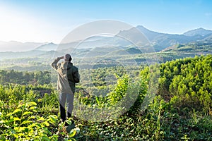 A hiker is looking at a tranquil, during sunrise in a mountainous wilderness Da Lat Vietnam