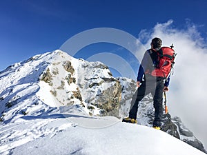 Hiker looks at a winter mountain landscape