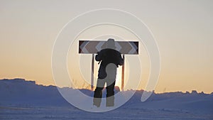 Hiker man with backpack choose in a road fork between two different path directions at the winter on road. Concept of