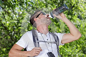 hiker man drinking water in forest on mountain