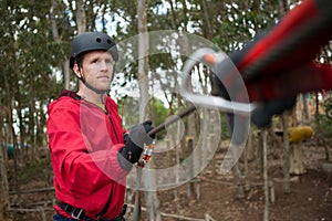 Hiker man holding zip line in forest