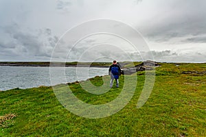 Hiker man in the Irish countryside in the coastal walk route from Doolin to the Cliffs of Moher