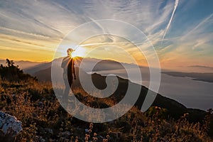 Hiker man with scenic sunrise view from top of mount Kula near Omis, Dinara mountains, Split-Dalmatia, Croatia. Coastal landscape