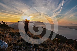 Hiker man with scenic sunrise view from top of mount Kula near Omis, Dinara mountains, Split-Dalmatia, Croatia. Coastal landscape