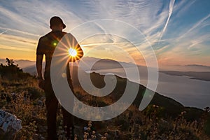 Hiker man with scenic sunrise view from top of mount Kula near Omis, Dinara mountains, Split-Dalmatia, Croatia. Coastal landscape