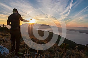 Hiker man with scenic sunrise view from top of mount Kula near Omis, Dinara mountains, Split-Dalmatia, Croatia. Coastal landscape