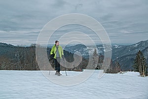 Hiker man with snow shoes and trekking poles