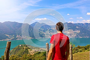 Hiker man standing admiring a mountaintop view looking out over distant ranges of mountains and valleys in a healthy