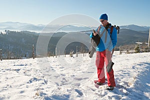 Hiker man standing with GPS receiver in winter mountains and de