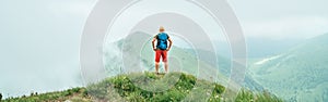 Hiker man walking by the cloudy and foggy weather mountain range path with backpack. Active sport backpacking healthy lifestyle