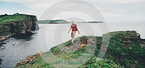 Hiker man walking on coastline near the sea