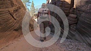 A Hiker Mature Woman Walks Between The Smooth And Wavy Rocks Of The Canyon