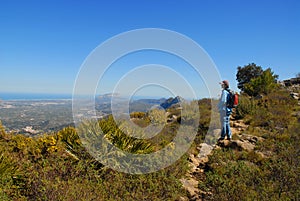 Hiker on a mountain track, admiring the view photo