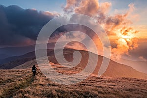 Hiker in mountains at breathtaking sunset