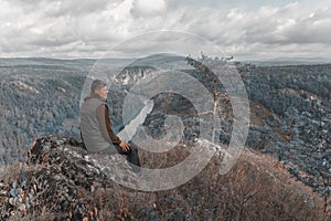 Hiker on a mountainside. Panorama of the South Ural taiga at dawn