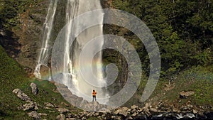 Hiker near waterfall with rainbow. Slow Motion Footage