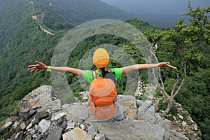 hiker open arms to the great wall on the top of mountain