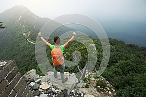 hiker open arms to the great wall on the top of mountain
