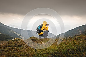Hiker photographing mountains in bad weather