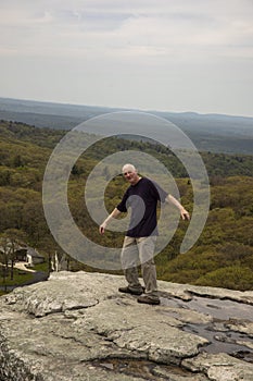 Hiker pretending to fall off Sam`s Point overlook, New York