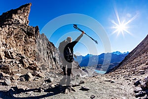 Hiker reaches a high mountain pass; he shows his joy at open arms.