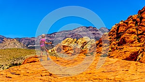 Hiker on the Red Sandstone Cliffs of the Calico Trail in Red Rock Canyon National Conservation Area, NV. USA