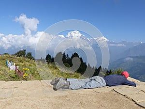 Hiker relaxing on Poon Hill, Dhaulagiri range, Nepal