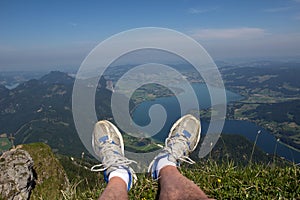 Hiker resting on a mountain top overlooking Wolfgangsee Lake in Strobl, Austria
