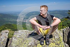 Hiker rests on the stone while hiking