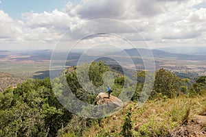 A hiker at a scenic view point at Ole Muntus Mountain Range in Sultan Hamud, Kenya