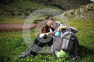 Hiker searching canteen from backpack