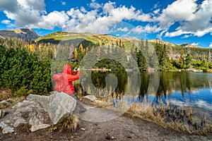 Hiker on the shore of mountain lake Jamske pleso in High Tatras mountains in Slovakia