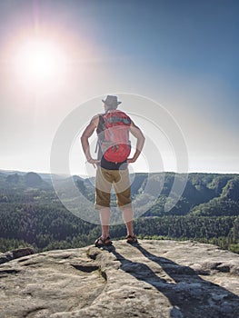 Hiker in shorts, black leather vest and leather crimson hat