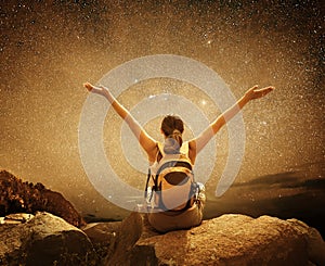 Hiker sit on top of a mountain and enjoying night sky view with