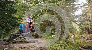 Hiker sitting on a rock using cellphone gps