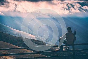 Hiker sitting on a wooden fence. Instagram stylisation