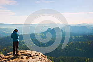 Hiker stand on the sharp corner of sandstone rock in rock empires park and watching over the misty and foggy morning valley to Sun