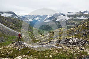 Hiker standing above glacial valley in Talkeetna Mountains, Alas