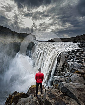 Hiker standing close to the Dettifoss waterfall in Iceland