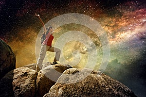 Hiker standing on top of a mountain and enjoying night sky view