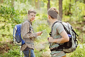 Hiker standing in the woods with a friend and looking at the cam