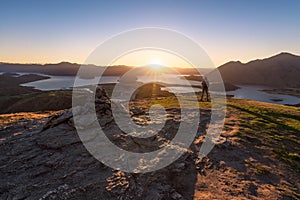 Hiker staring at the beauty of the sun rising star over Lake Wanaka in New Zealand during golden hour time