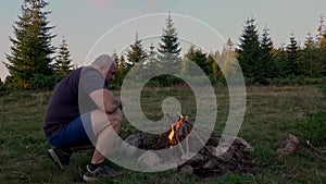 Hiker starting campfire at dawn