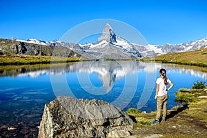 Hiker at Stellisee - beautiful lake with reflection of Matterhorn - Zermatt, Switzerland