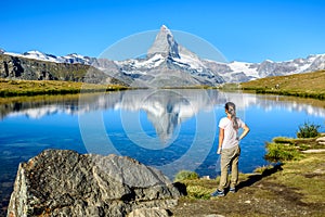 Hiker at Stellisee - beautiful lake with reflection of Matterhorn - Zermatt, Switzerland